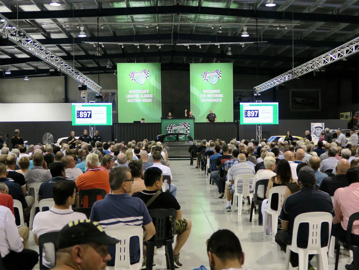A packed Shannons auction event with an audience watching the live bidding.