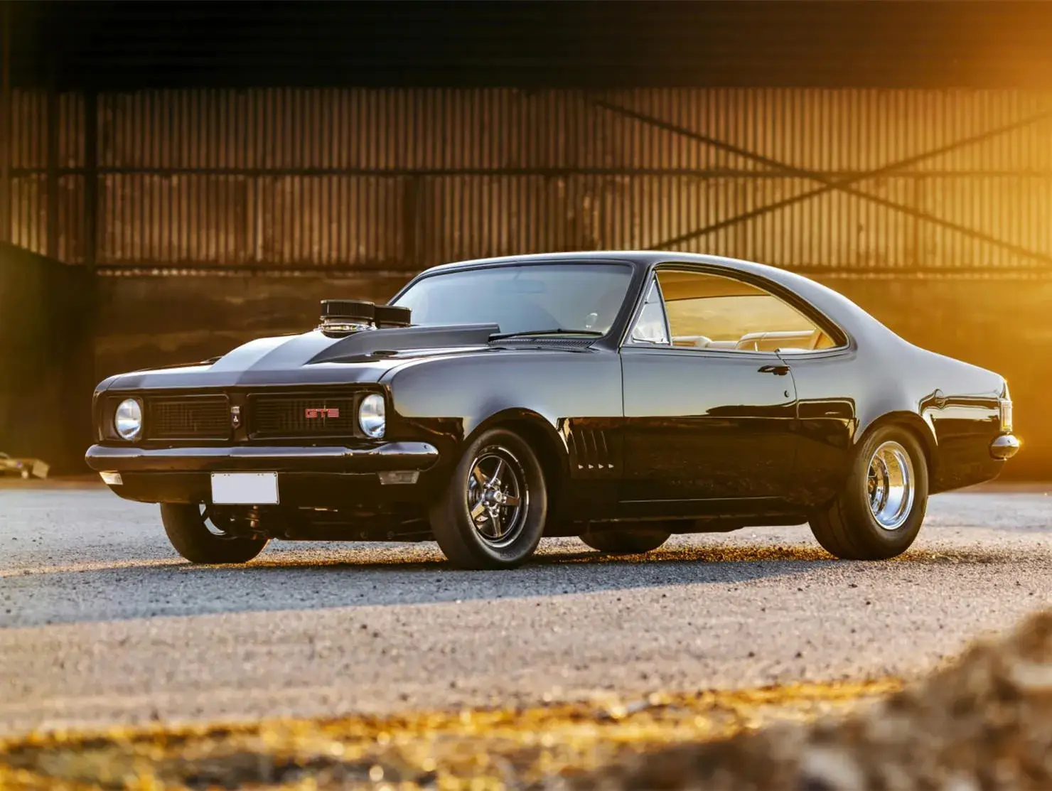Black Holden Monaro GTS at sunset, entered in the Shannons Club Online Show and Shine Competition.
