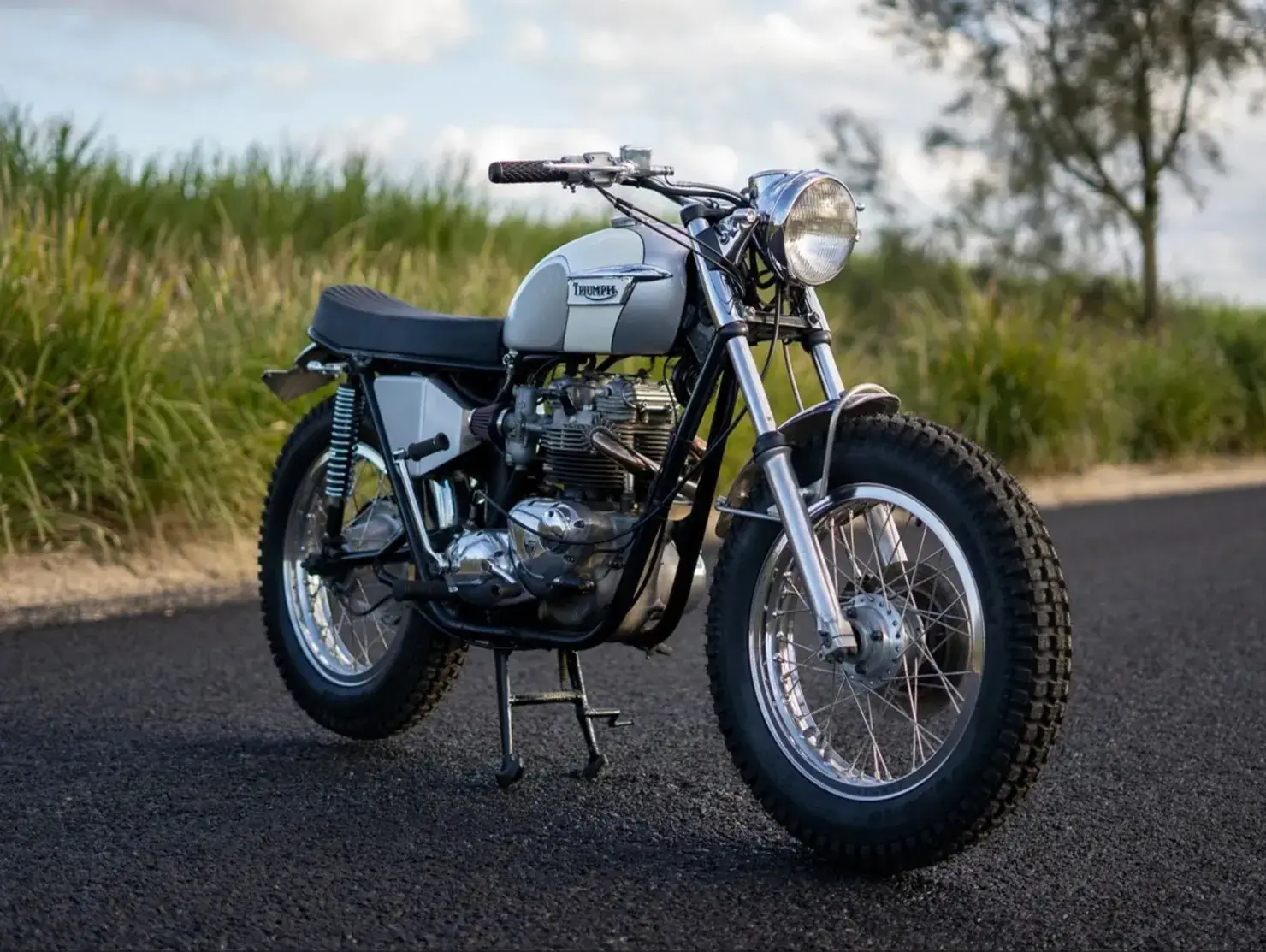 Classic Triumph motorcycle on a country road, entered in the Shannons Club Online Show and Shine Competition.