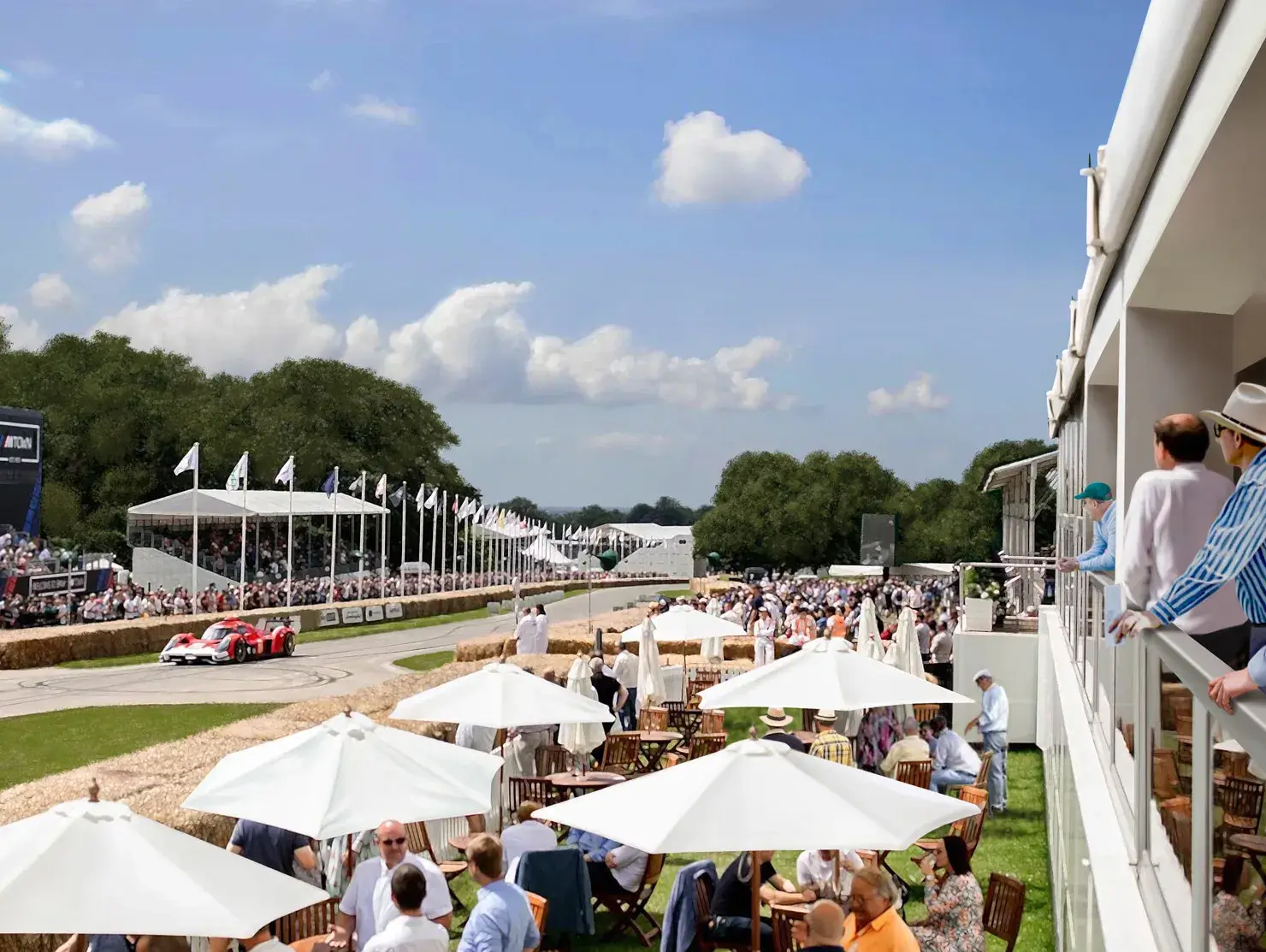 Hospitality area and trackside view of the Goodwood Festival of Speed with crowds and racing action, part of Shannons prize trip.