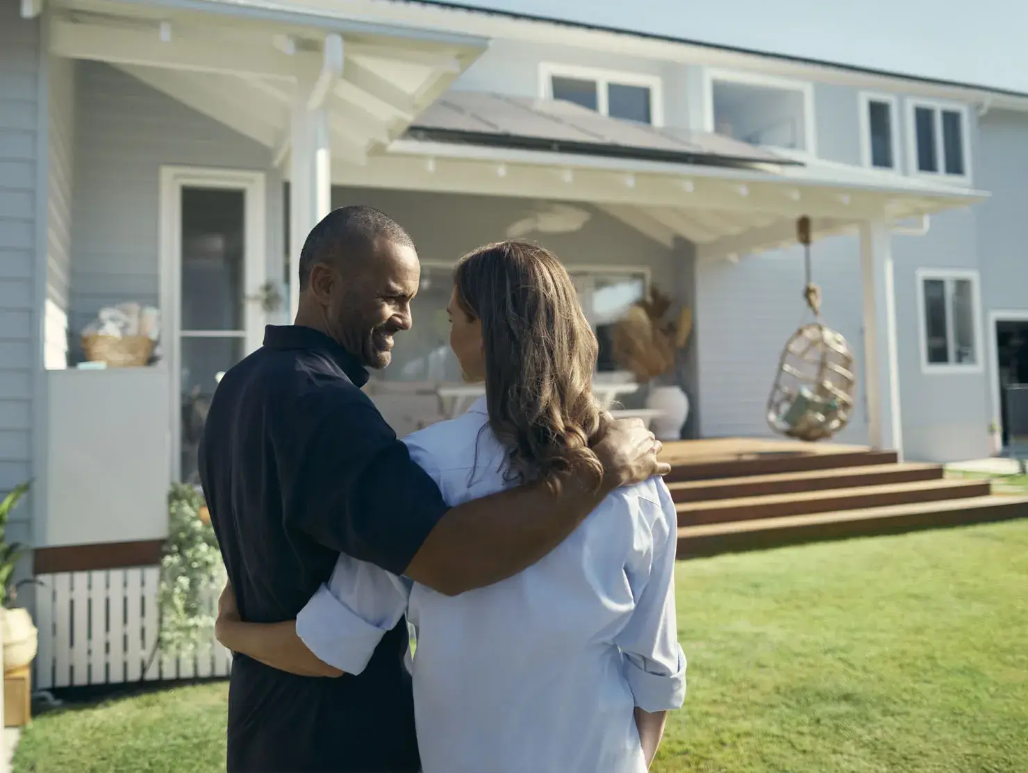 Couple embracing outside a holiday rental home, representing property protection with Terri Scheer Insurance.