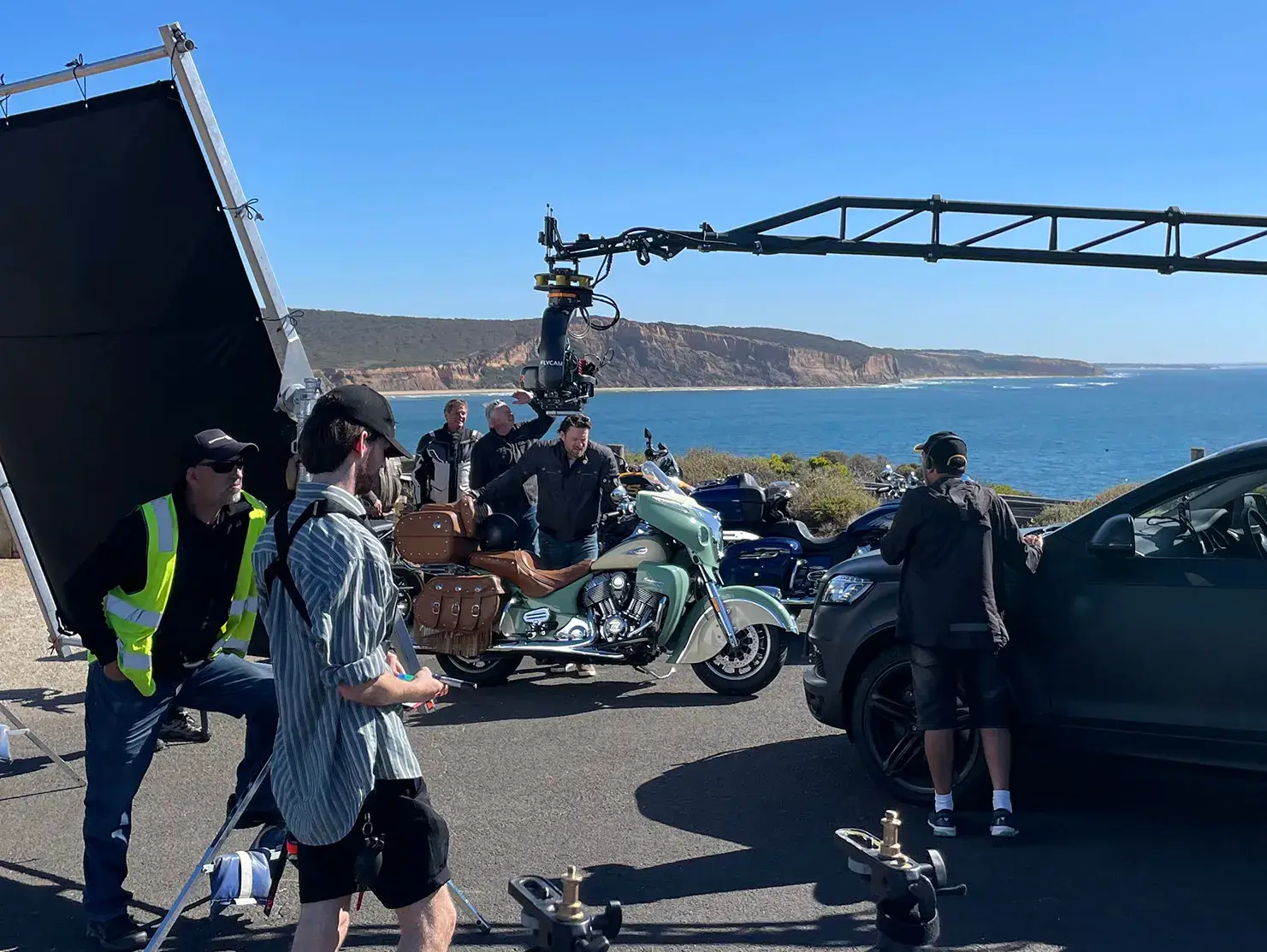 Behind-the-scenes filming for the Shannons Bike Insurance campaign, with crew capturing a classic cruiser against the coastline backdrop.