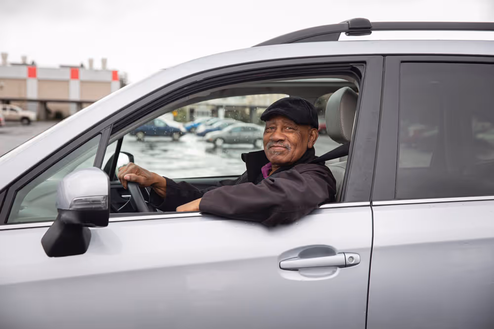 A man in a car with his window rolled down