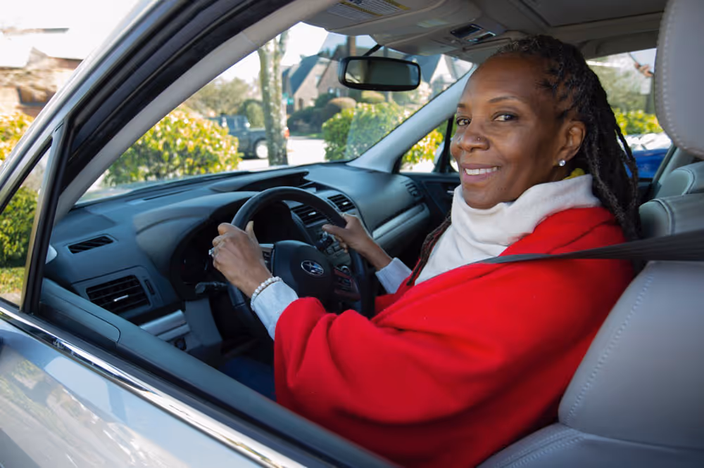 A women in a car with both hands on the steering wheel