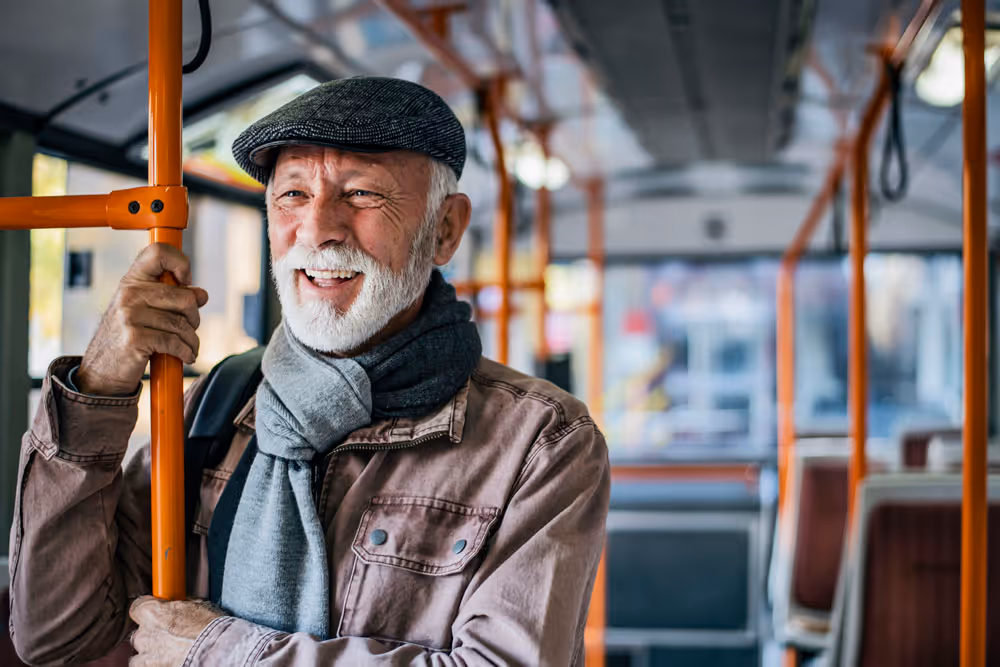 An older man riding a bus