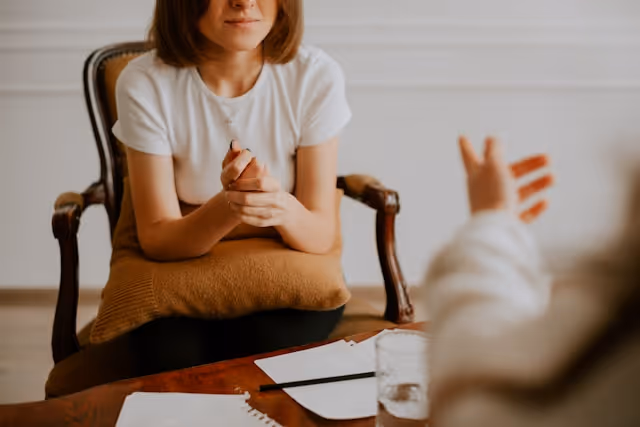 Woman in a t-shirt listening in a therapy session with a pillow