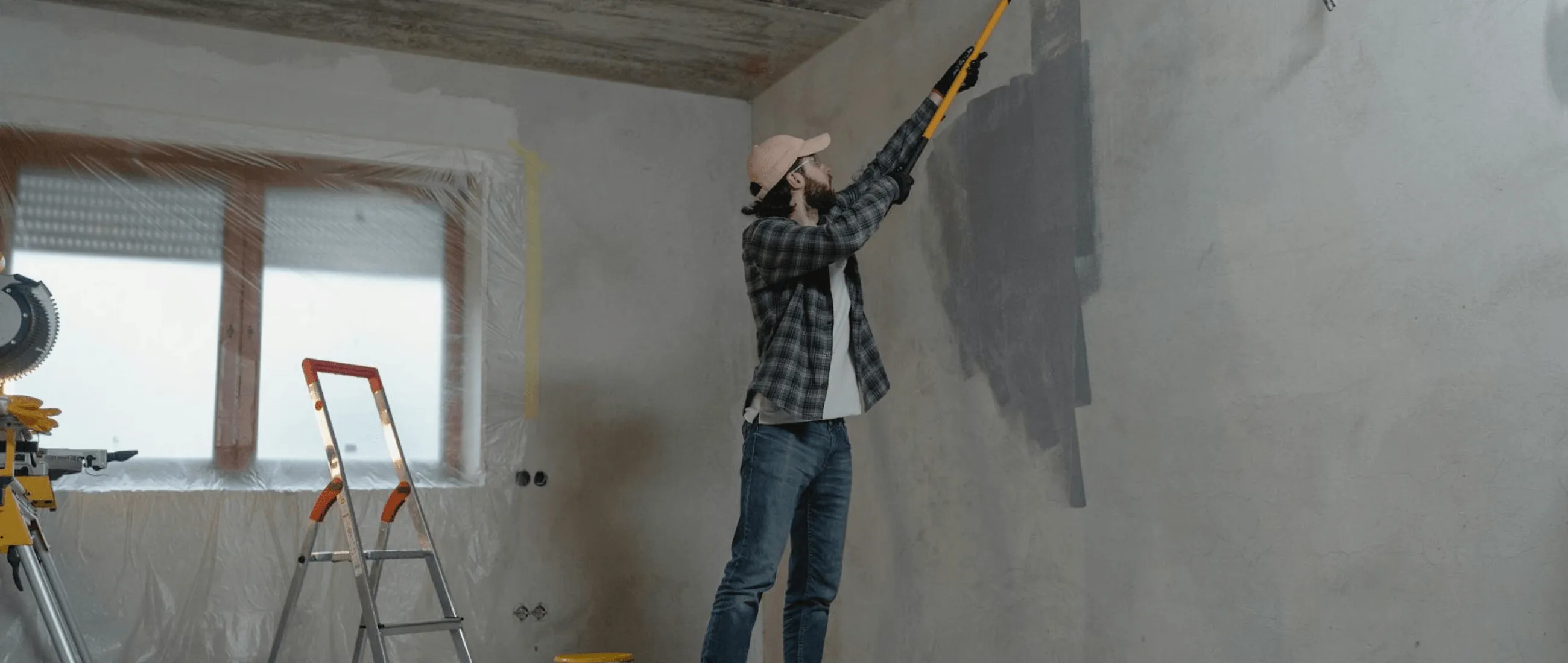 A PMB Property Improvements contractor painting a wall for a new remodel