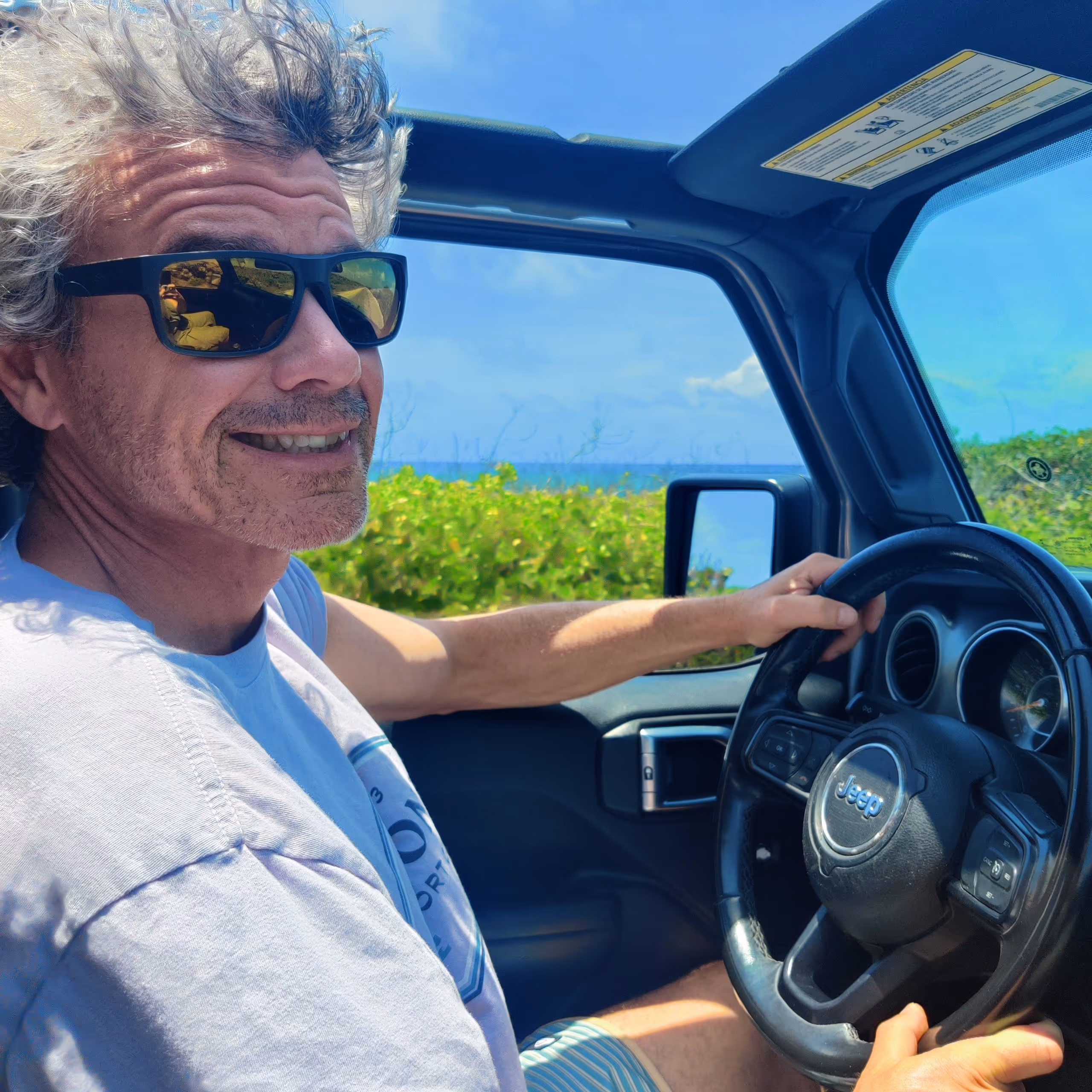 Chris C., from Denver, Colorado, driving with a big smile, windows down, relaxed and enjoying the moment.