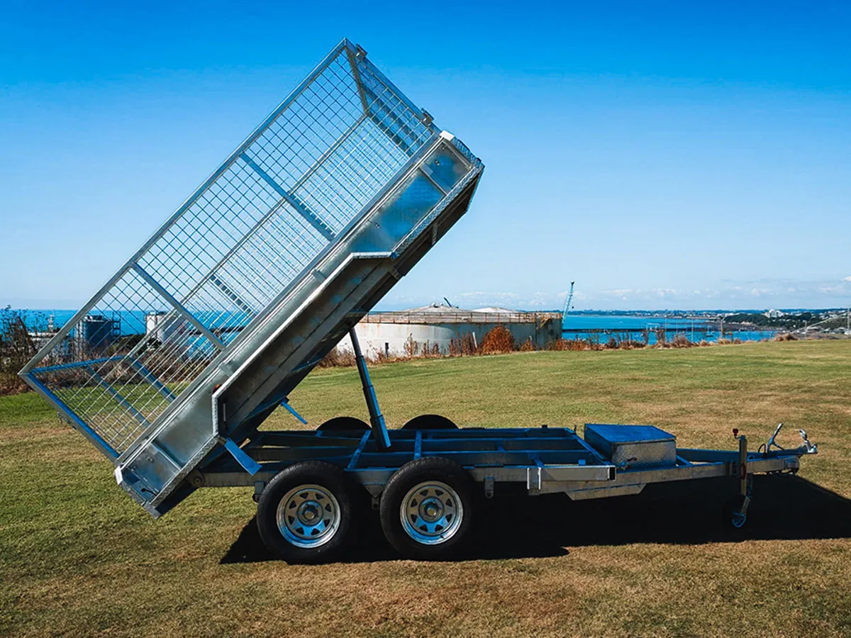 Metal tipper trailer with raised tipping bed.