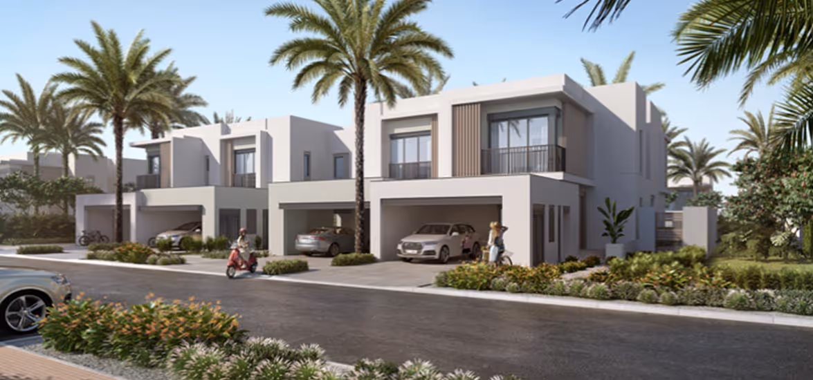 Modern two-story white houses with garages, parked cars, palm trees, and people near the driveways on a sunny day.