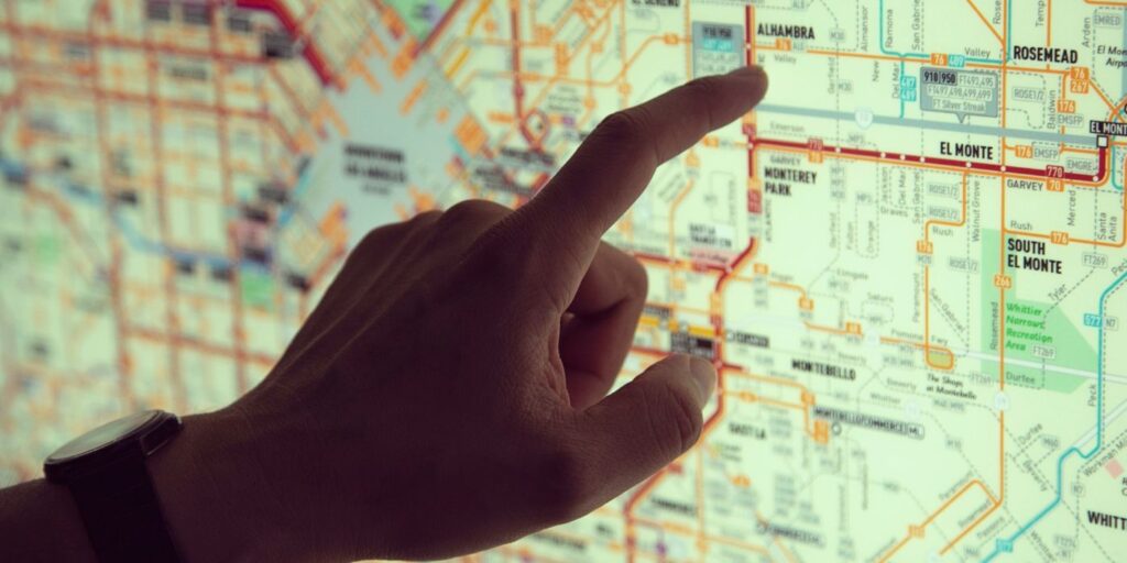 hand tapping a pin on a map