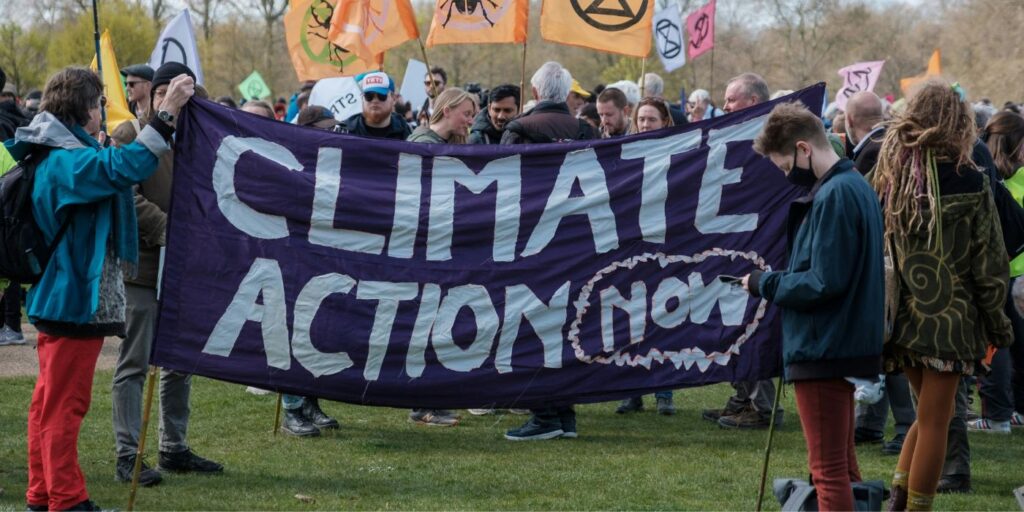 protest marching and holding a climate action now banner