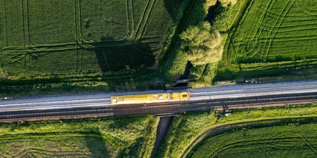 a train on a track travelling cross country across multiple fields 