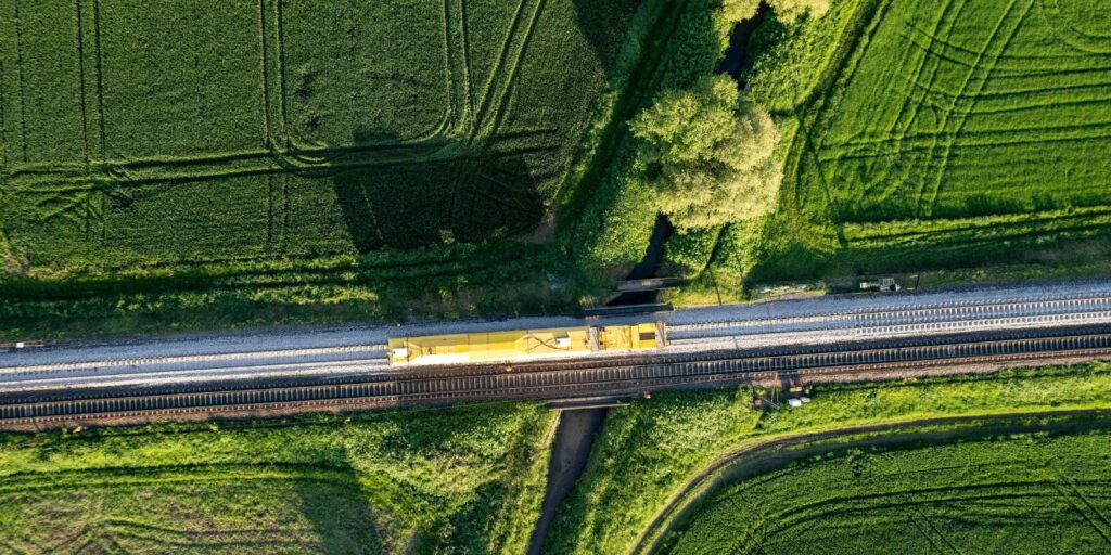 a train on a track travelling cross country across multiple fields 