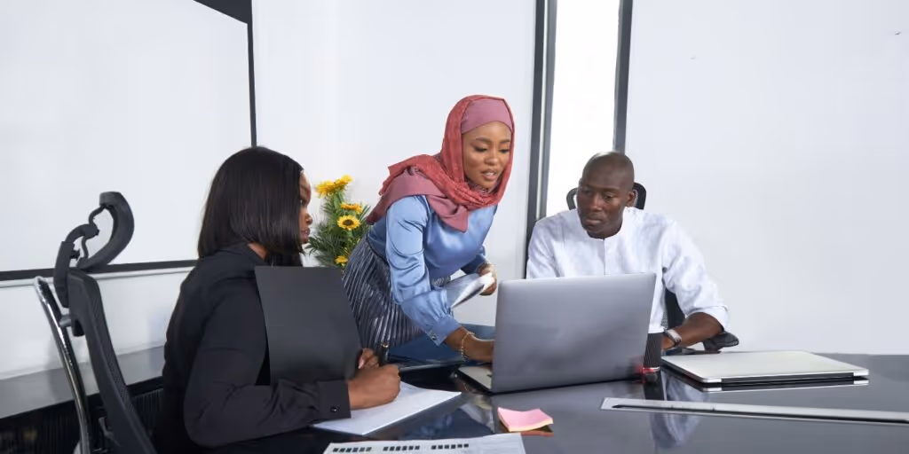 Three people reviewing something on a laptop