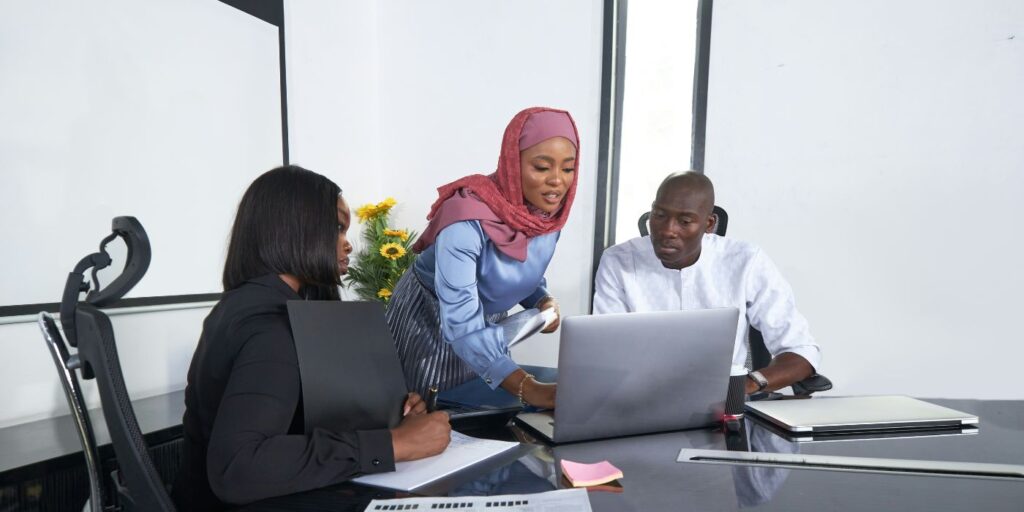 Three people reviewing something on a laptop