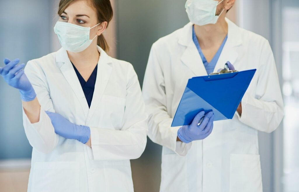 two medical professionals with one holding a clipboard