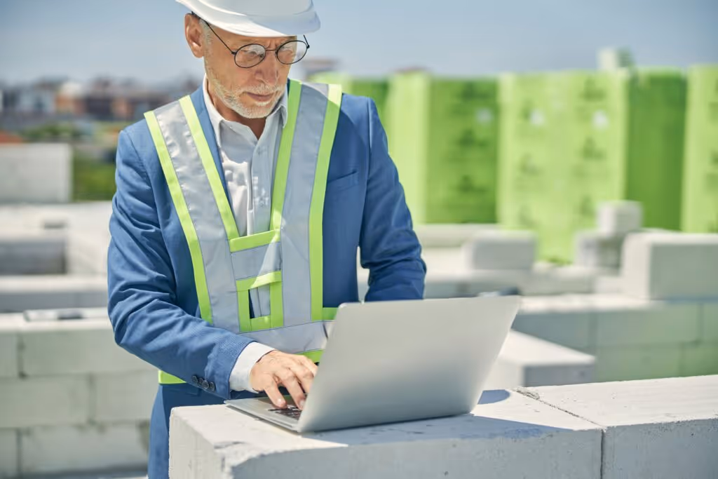 construction worker looking on laptop 
