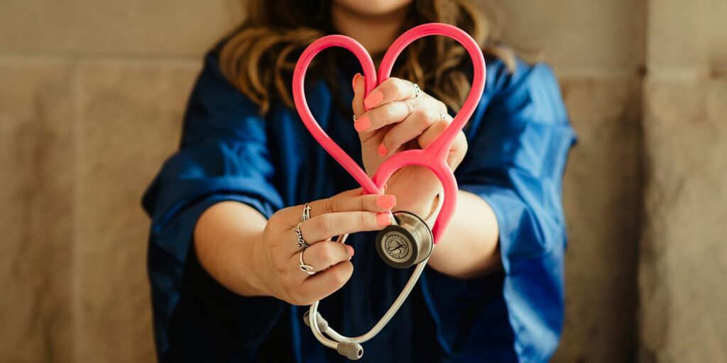 nurse holding up a stethoscope shaped like a heart