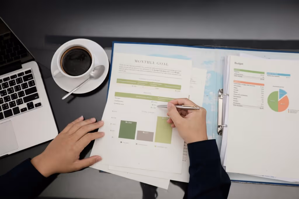 person looking at graphs and documents on paper