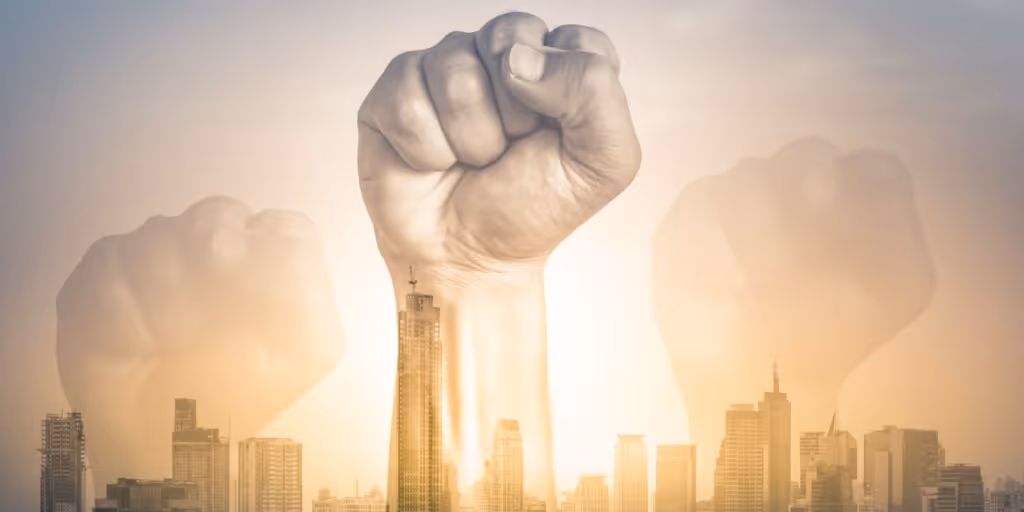fists raised above a skyline to symbolise radical change