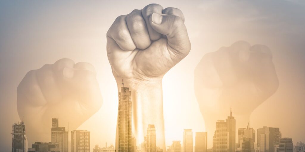 fists raised above a skyline to symbolise radical change
