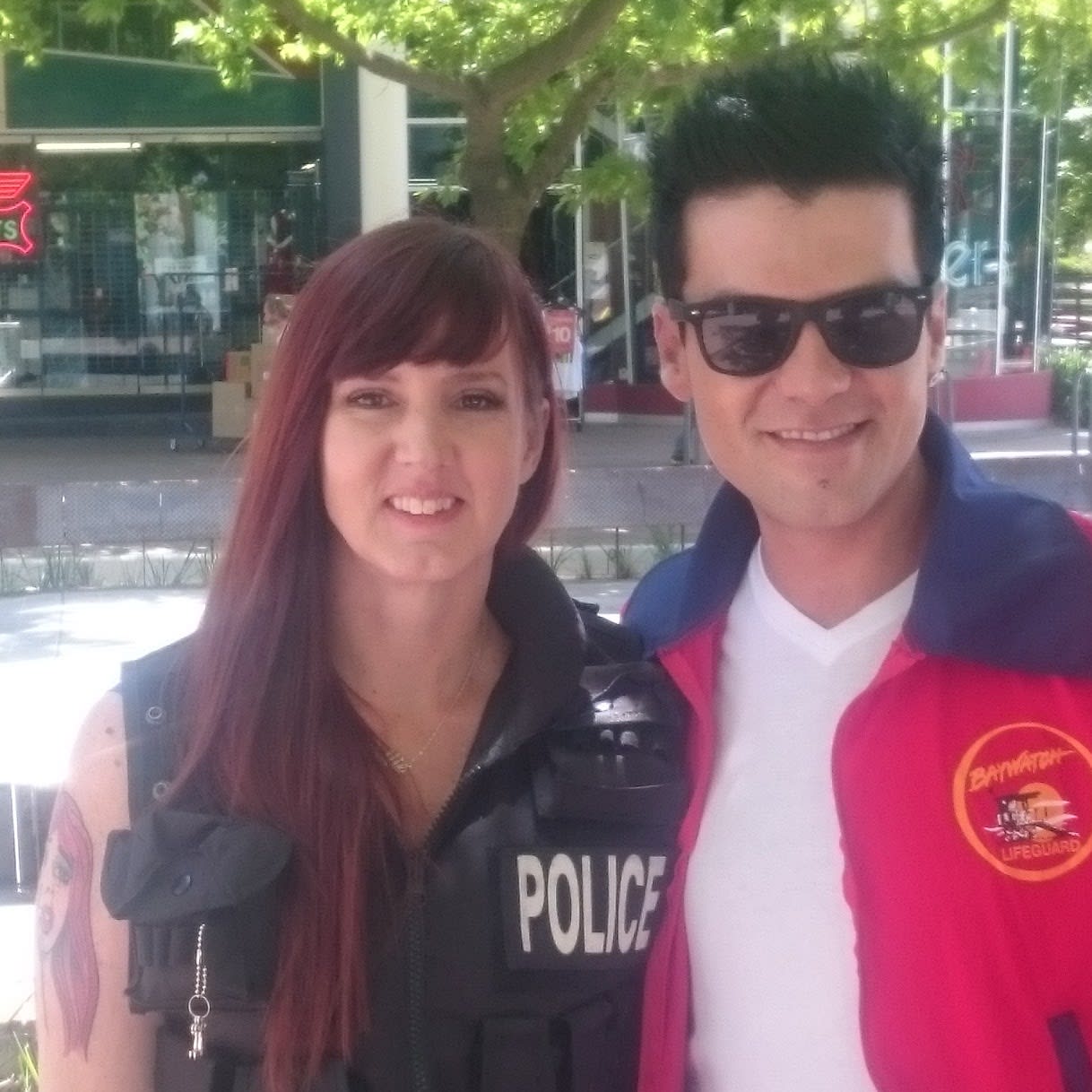 man with sunglasses, Glenn Cowling, and a woman with long red hair smile into camera