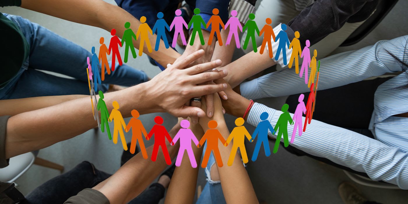 a collective group of hands all in the middle, placed upon each other