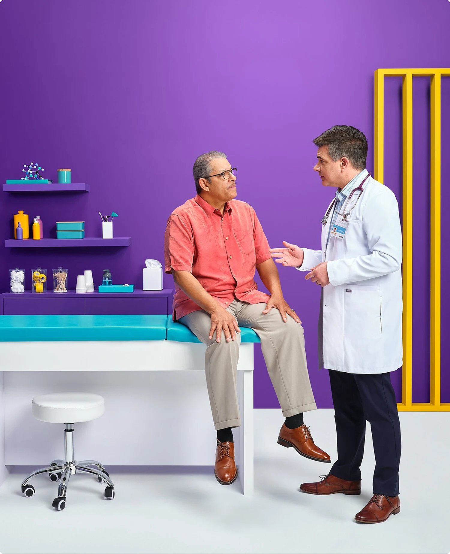 Brand photography for athenahealth showing a doctor consulting with his patient against a colorful, highly stylized office environment.