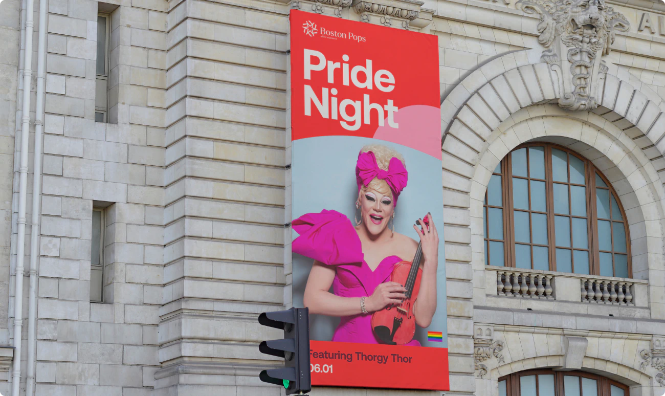 A large red banner outside Boston's Symphony Hall highlighting Pride Night, a celebration of LGBTQ+ pride with musician Thorgy Thor. Thorgy came to international attention on the eighth season of RuPaul's Drag Race. The design is a part of the BSO Brand Identity designed by Colossus Creative Co.