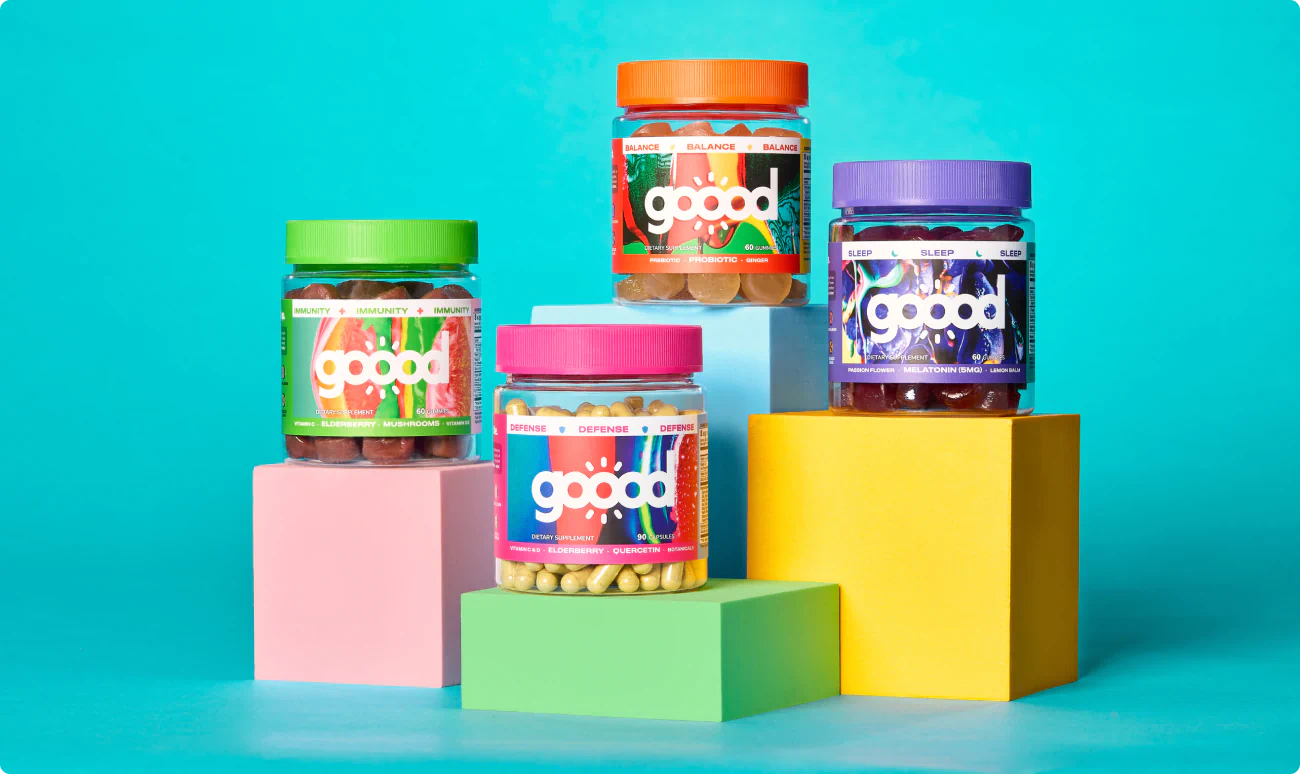 The Goood Wellness family of products displayed on colorful pedestals.