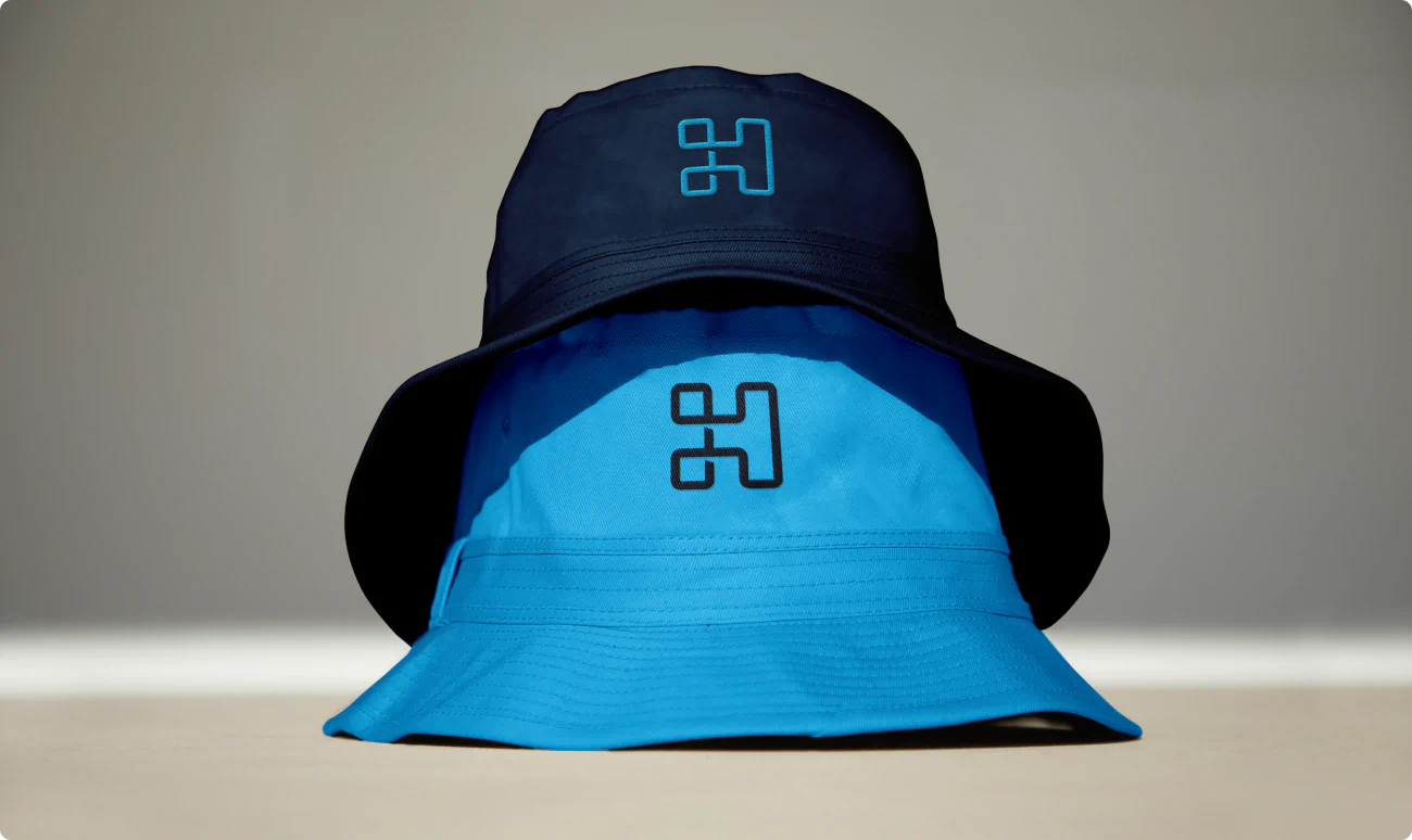 Logo on bucket hats. Apparel and merchandise design. A part of the B2B brand identity for Vaco Highspring developed by Colossus.