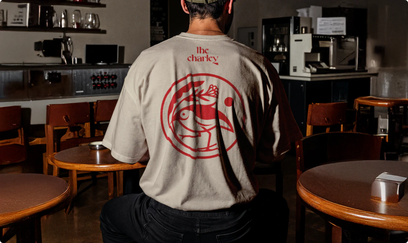 Cool tshirt design for commercial real estate project. White shirt with red bird logo.