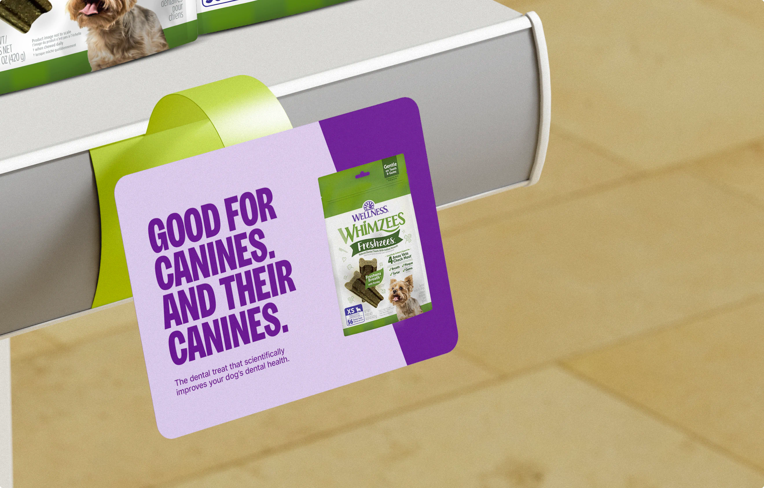 An aisle violator ad in a pet store for Wellness Whimzees Pet Dental Treats. The tag reads: "Good for canines. and their canines."