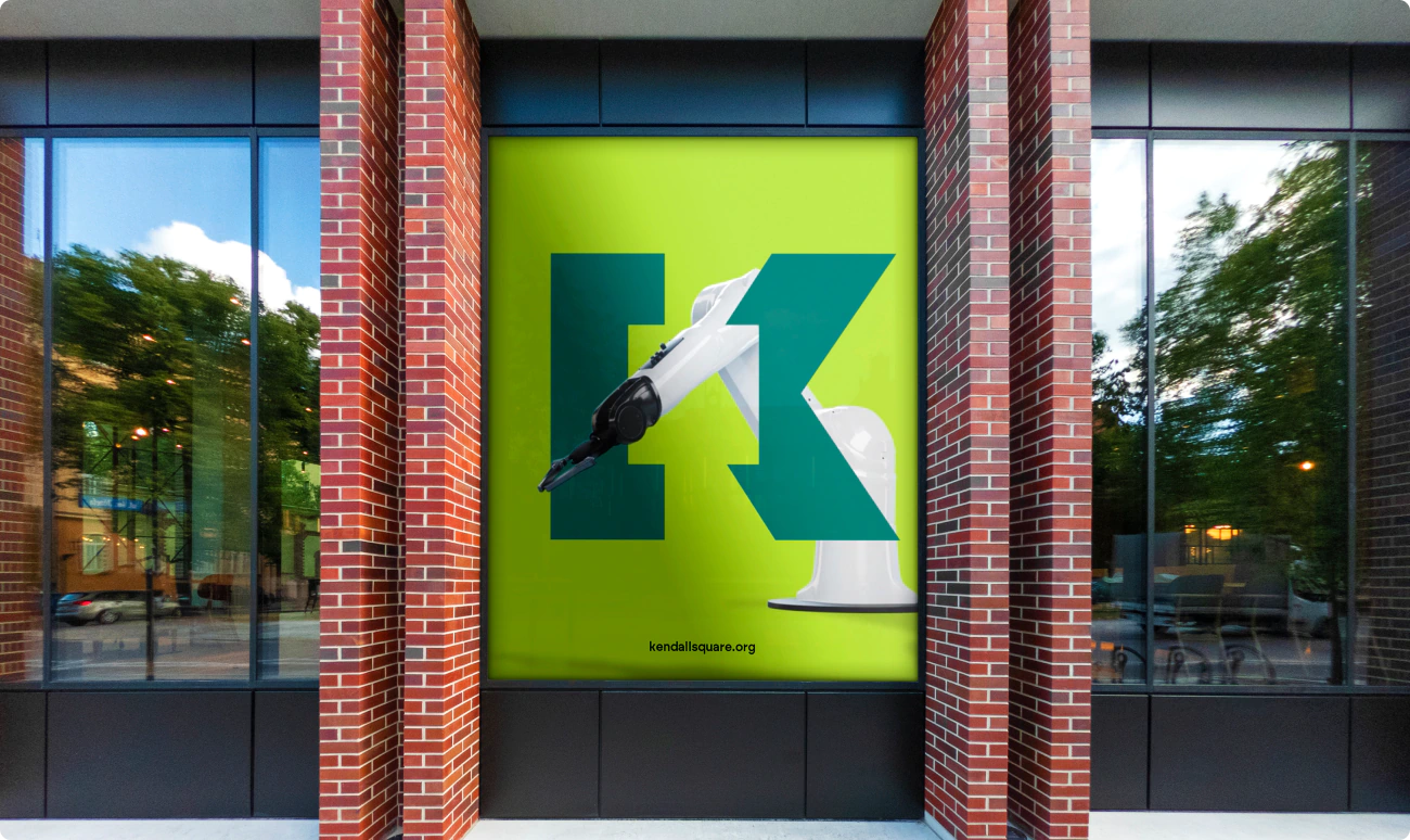 Street level window signage for KSA using the logo and a robotic arm.