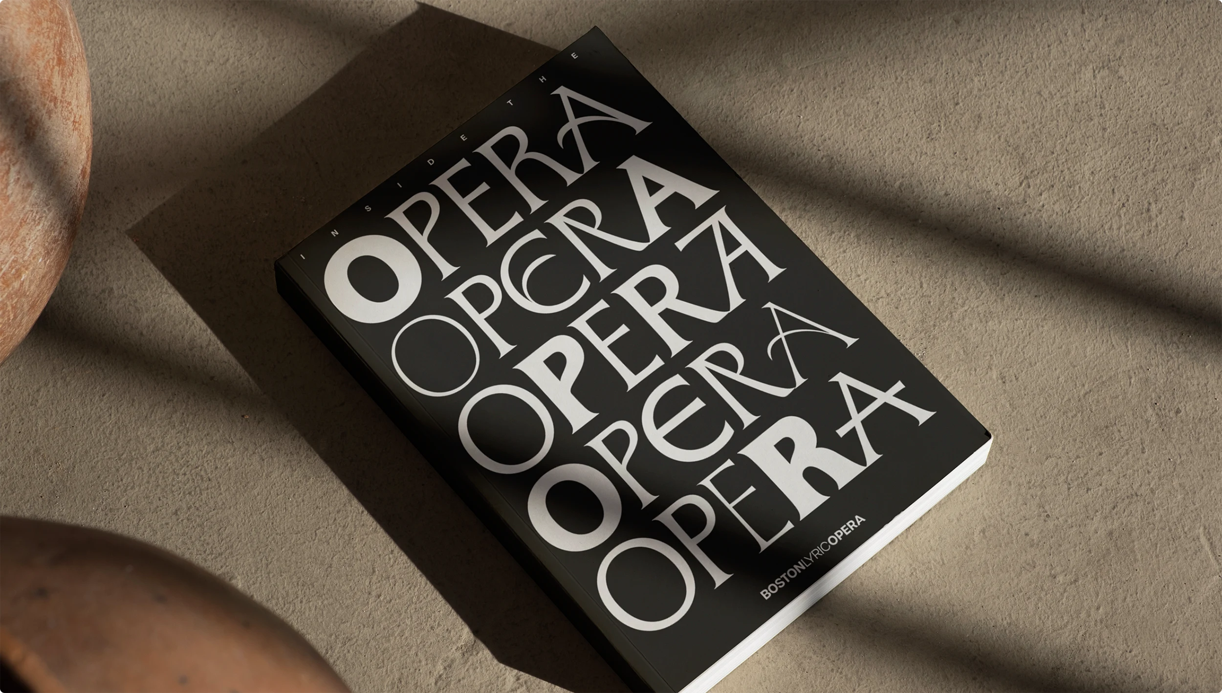 Book showcasing the flexible typographic system for Boston Lyric Opera. Black book in moody shadows.