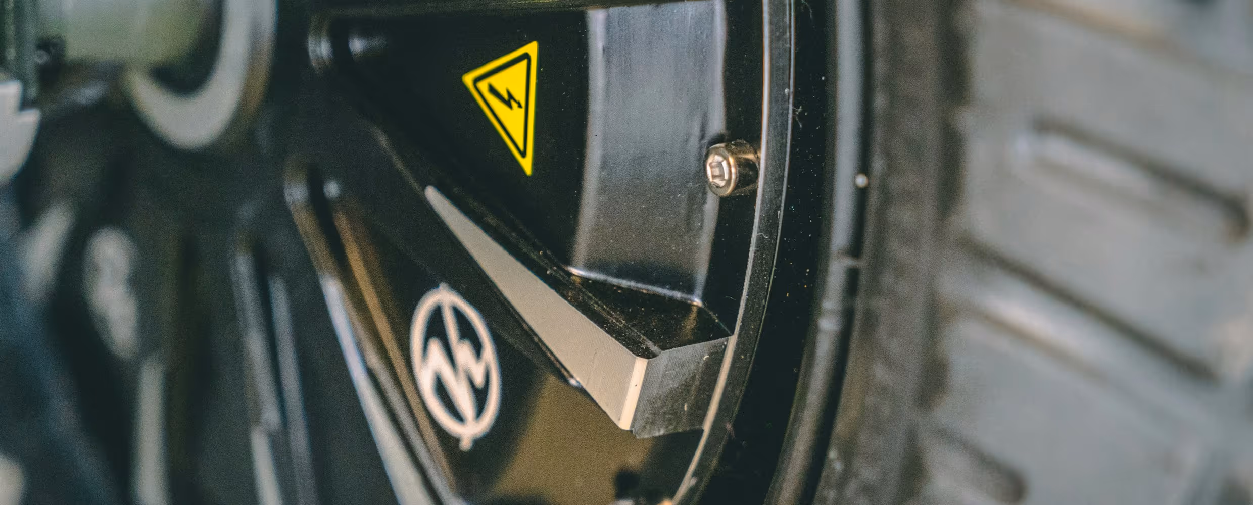 A close-up of a black tire with an electric hazard warning symbol on the side.