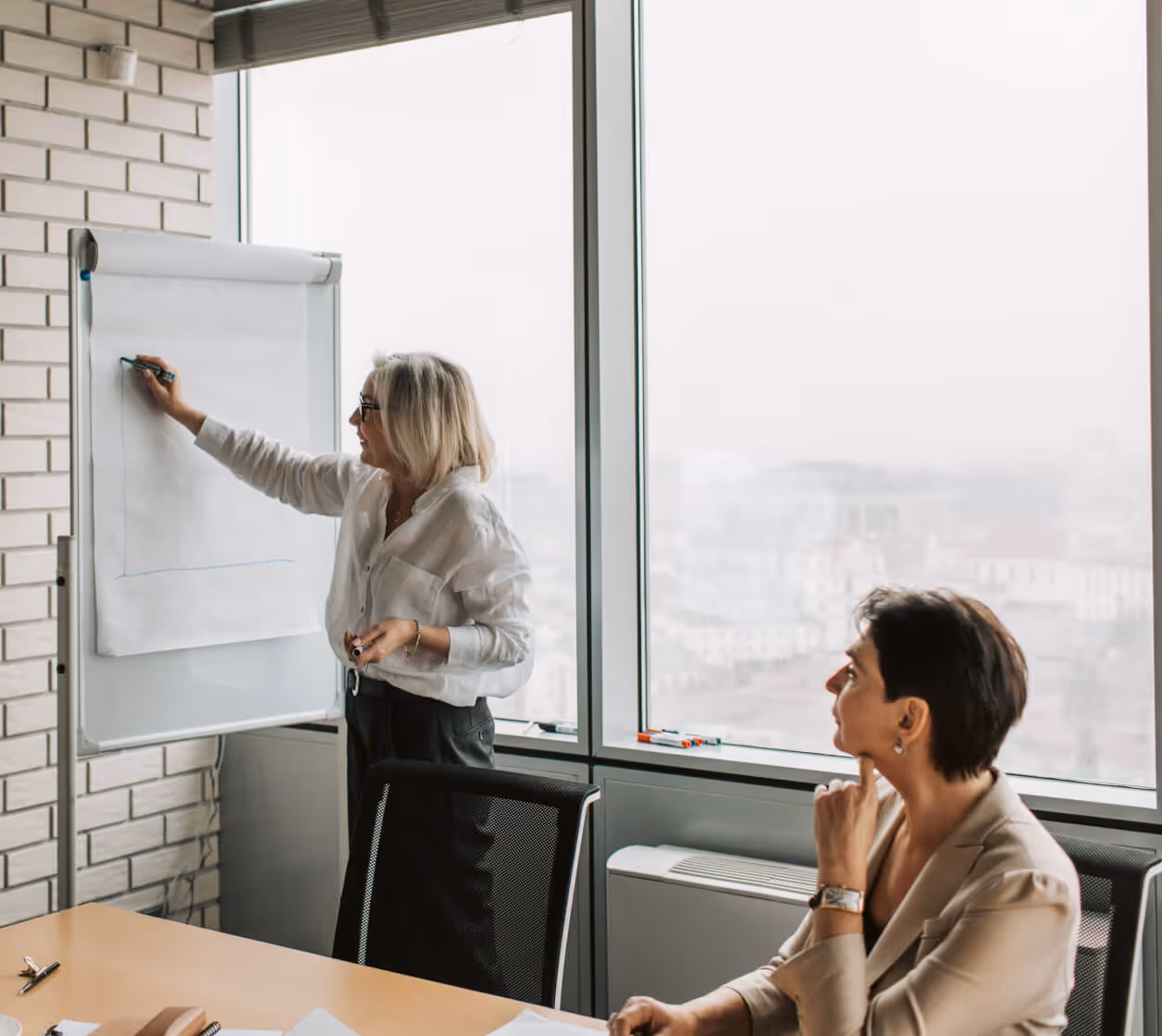 Woman is righting in white board and explaining