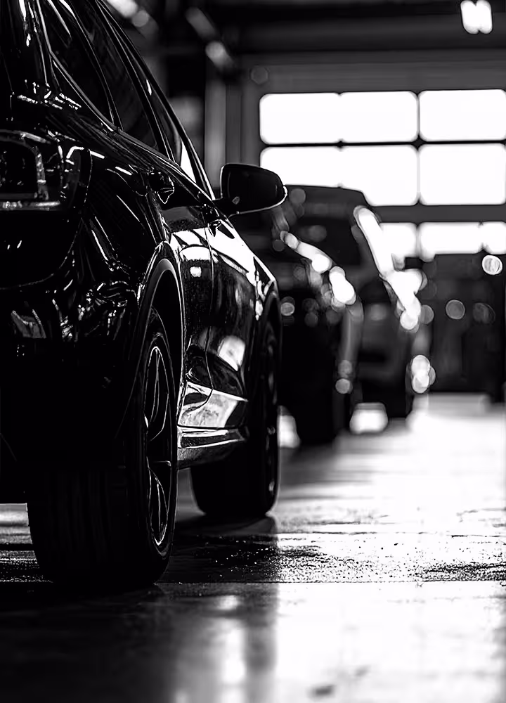 Wide shot of Cooper’s Garage interior showing vehicle lifts, European cars, and a clean, organized service bay