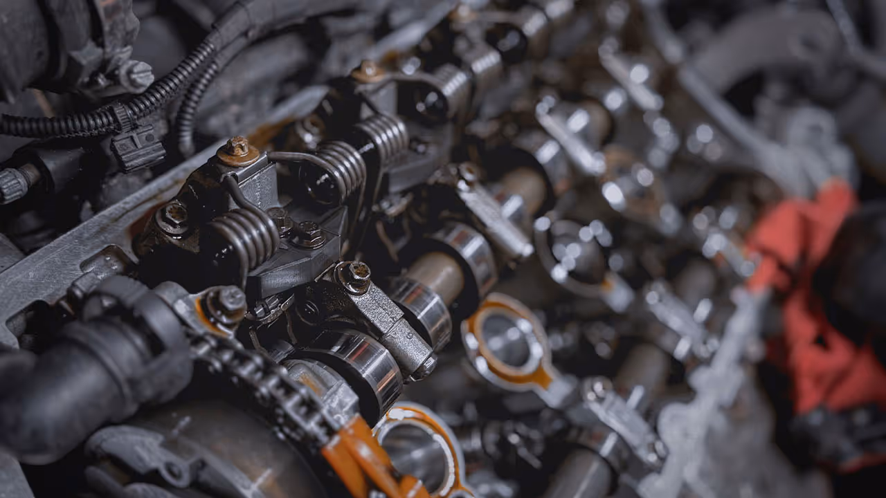 Detailed close-up of engine valvetrain components during disassembly for repair

