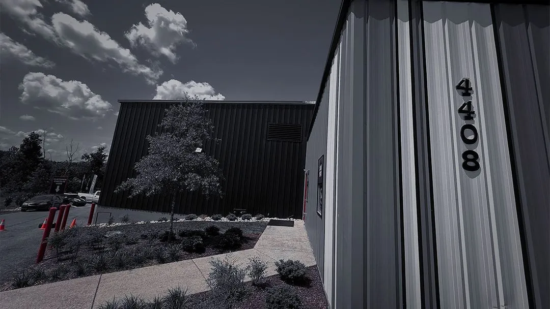 Side angle of the Cooper’s Garage exterior showing address number 4408 and landscaped entrance


