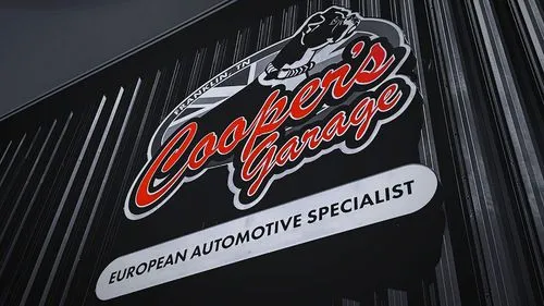 Close-up of the Cooper’s Garage building sign reading “European Automotive Specialist” mounted on the shop exterior