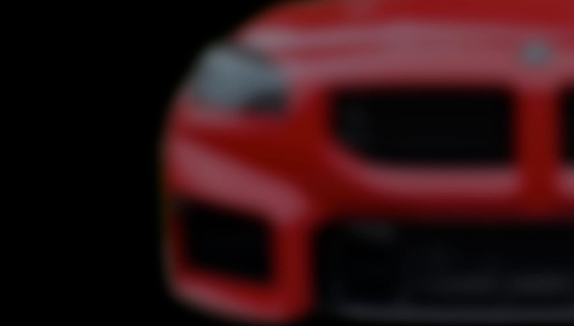 Blurred close-up of the front end of a red BMW, used as a background image.