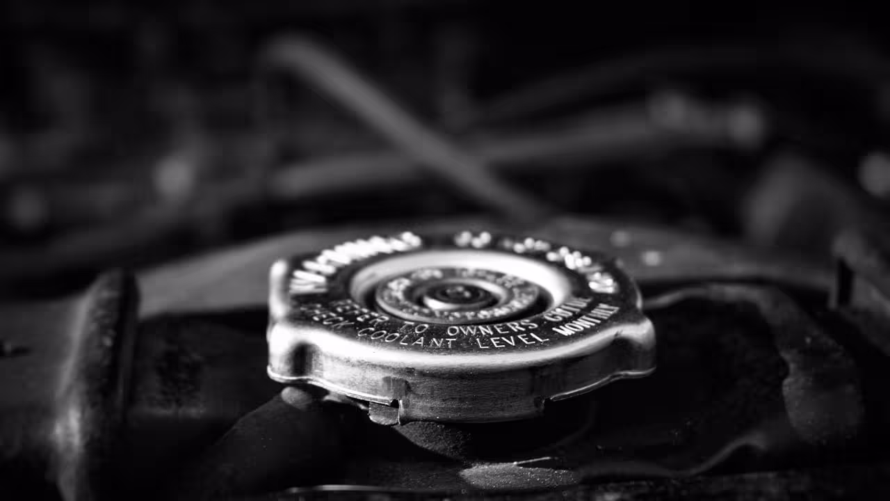 Close-up of radiator cap on engine bay during radiator replacement service.