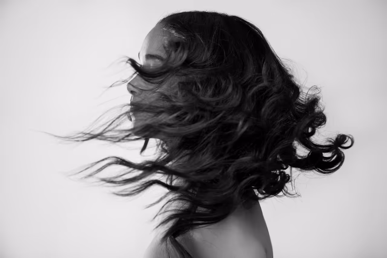 Schwarz-Weiß-Porträt einer Frau mit wehenden Haaren, Teil des Webdesign-Projekts Mira Beauty aus Köln
