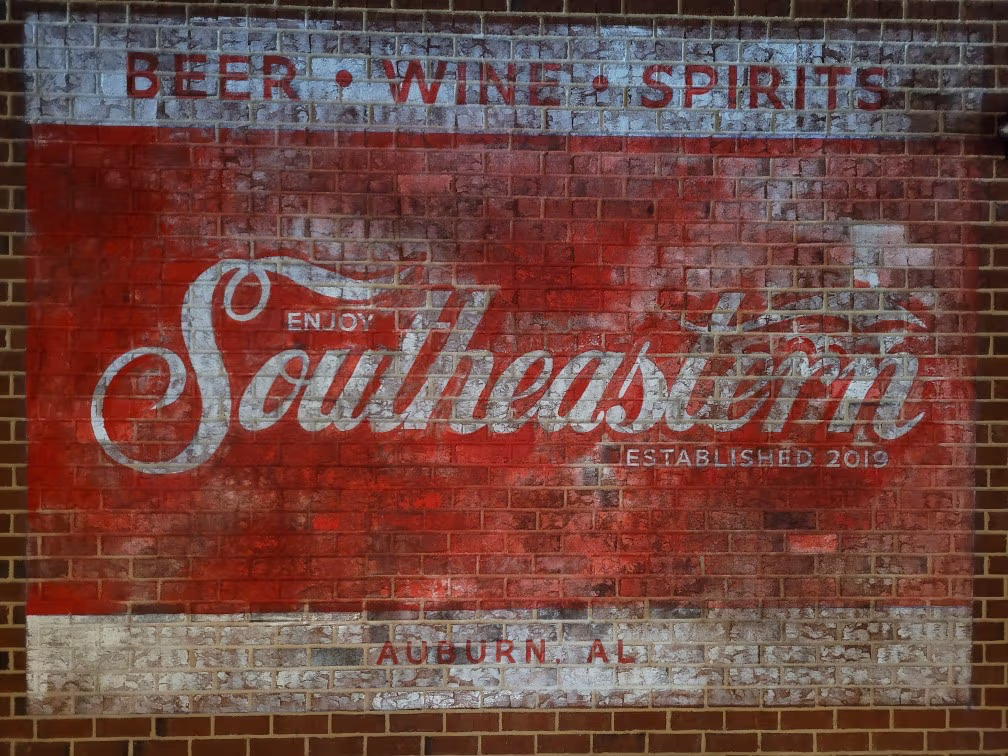 Professional hand-painted ghost sign restoration for South Eastern company, featuring vintage-style typography and weathered finish in Birmingham, Alabama