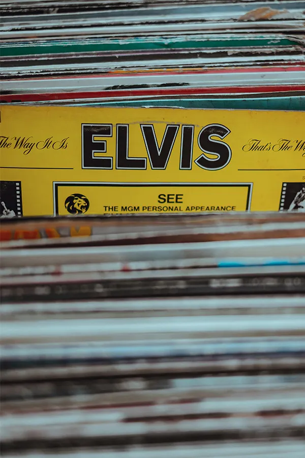 Eine Nahaufnahme von Schallplatten in einer Kiste, mit einem gelben Plattencover, auf dem ELVIS zu lesen ist.
