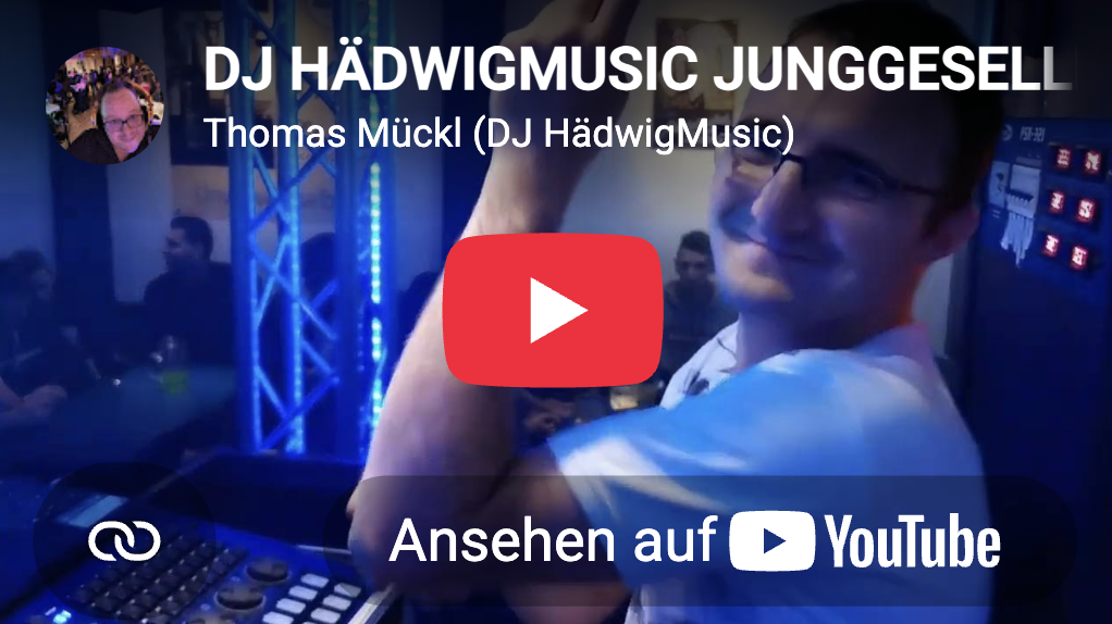 DJ HädwigMusic Junggesellenfeier mit Thomas Mückl an den DJ-Pulten, blickt lächelnd zur Kamera in einem Club mit blau beleuchteter Bühne.