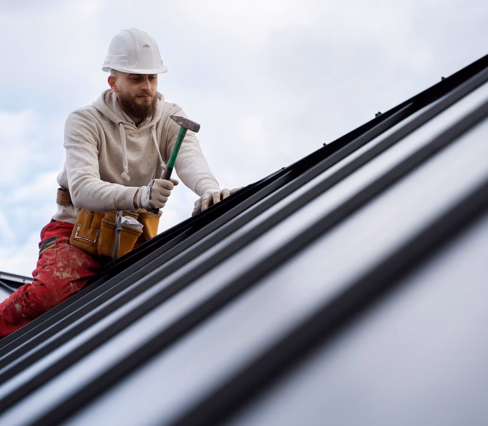 A professional roofer from Roof Tek installs a modern metal roof.