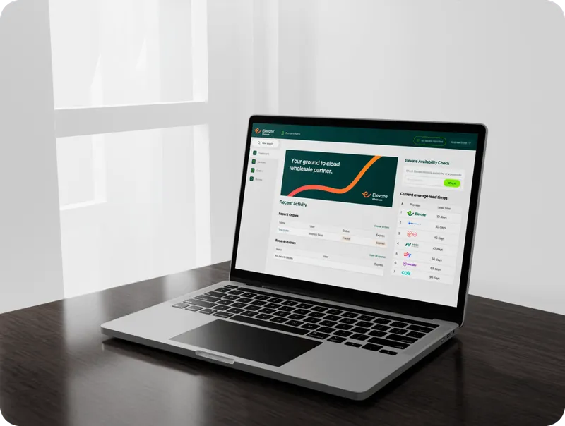 Laptop displaying a dashboard for a cloud wholesale partner with recent activity and availability check on a dark wooden table near a window.